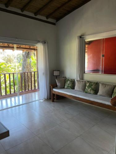 a living room with a couch and a large window at Residencial Lima in Trancoso