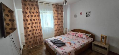 a small bedroom with a bed and a window at Casa Melcilor in Mangalia