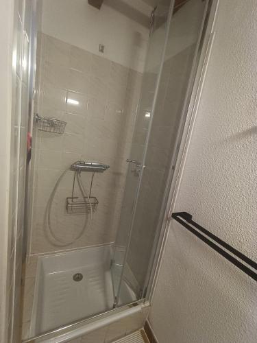 une douche avec une porte vitrée dans une salle de bain dans l'établissement Maison à 800m de la plage classée 1 étoile, à Capbreton