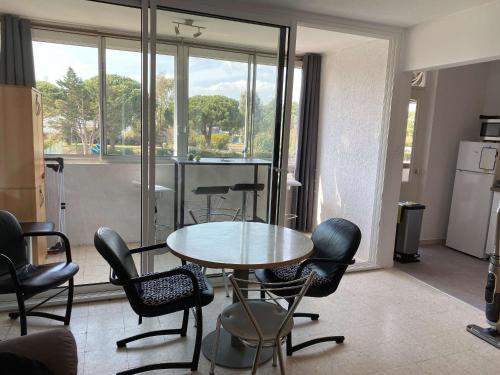 une pièce avec une table et des chaises et une cuisine dans l'établissement Appartement 3 pièces tout confort avec loggia fermée et équipements modernes, proche des Thermes - FR-1-553-208, à Balaruc-les-Bains