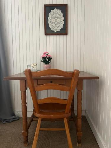 a wooden table with a wooden chair and a plant on it at Auberge Les Sources in La Malbaie