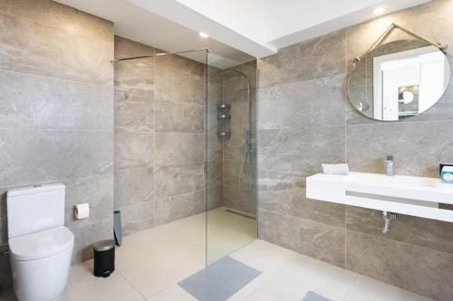 ein Badezimmer mit Toilette, Waschbecken und Spiegel in der Unterkunft Villa de lujo Concordia Piscina climatizada y excelentes vistas in Puerto de la Cruz
