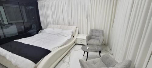 una piccola camera da letto con un letto e una sedia di Penthouse in Ramat Gan Next to Sheba Hospital a Ramat Gan