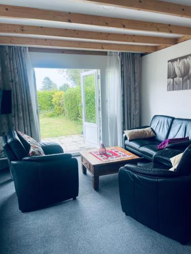 a living room with two couches and a coffee table at Mooie chalet met grote tuin dichtbij Amsterdam in Opmeer