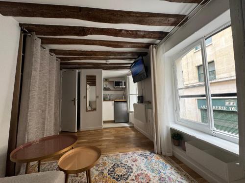 un salon avec une table et des chaises et une fenêtre dans l'établissement Studio Tout Équipé Bourse, à Paris