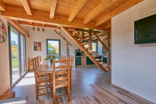une cuisine et une salle à manger avec une table et des chaises en bois dans l'établissement Le Refuge des Loups Blancs, à Ouhans