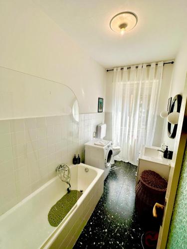 a bathroom with a tub and a toilet and a sink at Spacious, minimalist, chic "Maison de Fleurs" in Malgrate