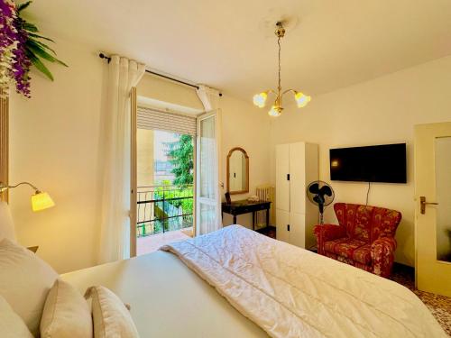 a bedroom with a bed and a window and a chair at Spacious, minimalist, chic "Maison de Fleurs" in Malgrate