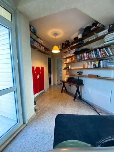 a living room with a desk and books at Private villa suitable for families with stunning sea views in Buyukcekmece