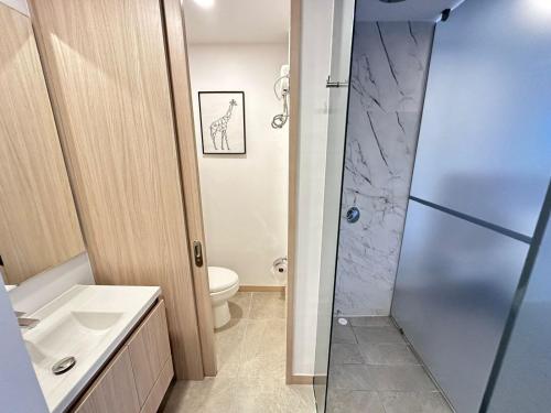 a bathroom with a toilet and a sink and a shower at Belmonte403-Hermoso apartaestudio en avenida centenario in Armenia