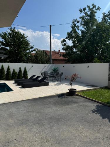 a patio with a table and chairs and a fence at Villa Sunrise with swimming pool in Sarajevo