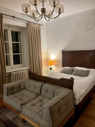 a bedroom with a large bed and a couch at Studio apartament, Dwor Kuflew in Kuflew