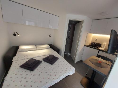 a bedroom with a bed with two black towels on it at Apartments R&B in Baška