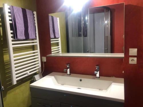 a bathroom with a sink and a large mirror at Kindia au Mans Maison 7pers, 3km circuit des 24H in Arnage