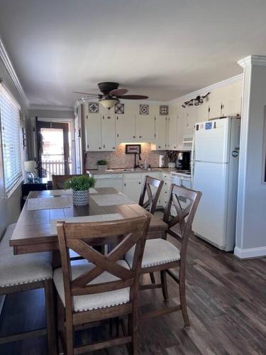 a kitchen with a table and chairs and a white refrigerator at Inlet Point Villas 12E Cherry Grove Beach "The Point" in Myrtle Beach