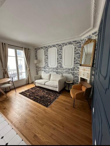 - un salon avec un canapé blanc et un miroir dans l'établissement Charming Parisian Flat near Eiffel Tower, à Paris
