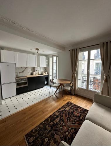 un salon avec une table et une cuisine dans l'établissement Charming Parisian Flat near Eiffel Tower, à Paris