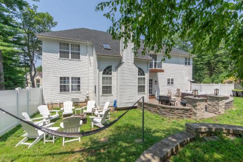 a yard with chairs and a table and a house at Luxury Villa- Hot Tub-King Bed Suite-Fenced Yard-Game Room-Fire Pit-Ski in East Stroudsburg