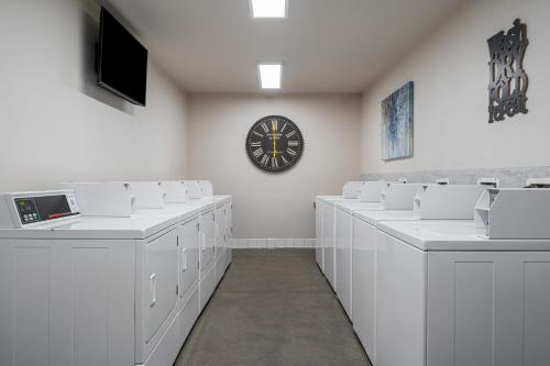 a room with white tables and a clock on the wall at Sun Outdoors Paso Robles in Paso Robles