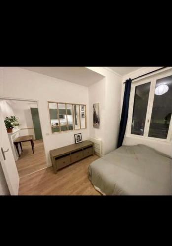 une chambre avec un lit, une table et une fenêtre dans l'établissement Appartement lumineux refait à neuf, à Rouen