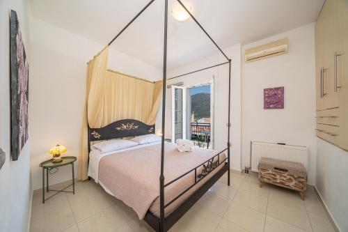 a bedroom with a canopy bed and a balcony at Blue Villa in Sami
