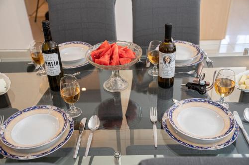 a table with two bottles of wine and a bowl of fruit at Blue Villa in Sami