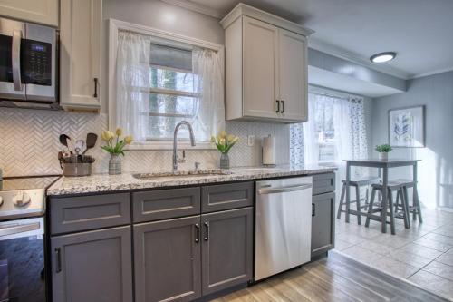 a kitchen with white cabinets and a sink and a table at Rocksteady Atlanta Decatur in Decatur