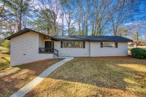 a white house with a black roof on a yard at Rocksteady Atlanta Decatur in Decatur