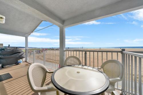 a balcony with a table and chairs on the beach at 1404 W Oceanfront B in Newport Beach