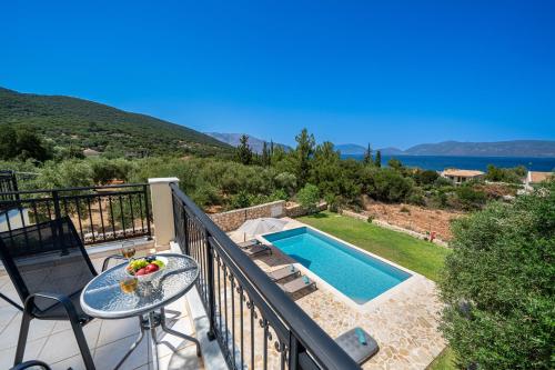 a balcony with a table and a swimming pool at Blue Villa in Sami