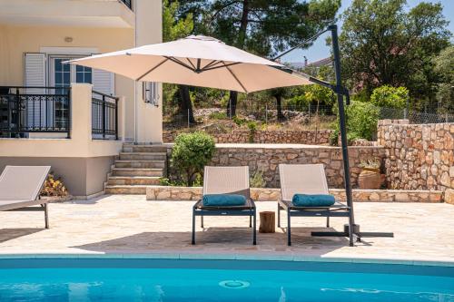 two chairs and an umbrella next to a pool at Blue Villa in Sami