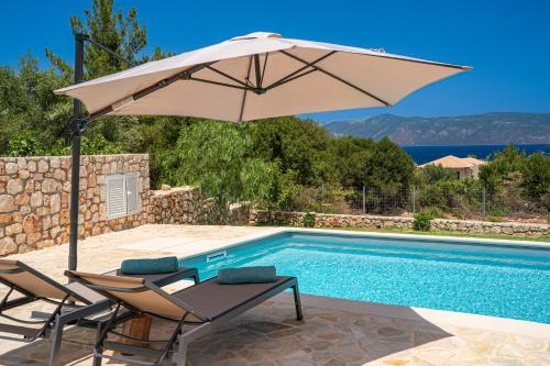 a pool with an umbrella and two chairs and a table with an umbrella at Blue Villa in Sami