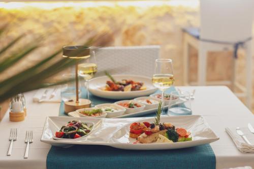 a table with plates of food and glasses of wine at Likya Pavilion Hotel in Kas
