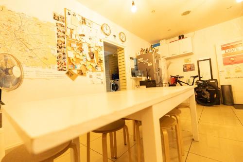 - un grand comptoir blanc dans une pièce avec tabourets dans l'établissement Korean Style Minbak Number Two PARIS, à Paris