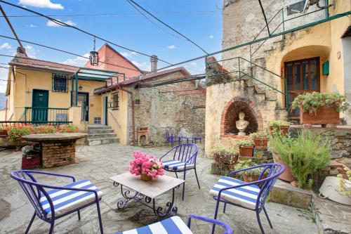 a patio with chairs and tables and a building at Ca Veggia for nature lovers - Happy Rentals in Stellanello