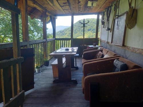a screened in porch with couches and a table at Etno kuća Milidrag in Foča