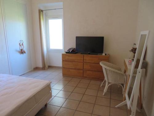 - une chambre avec une télévision et une commode avec un lit dans l'établissement Location de vacances, à Casalabriva