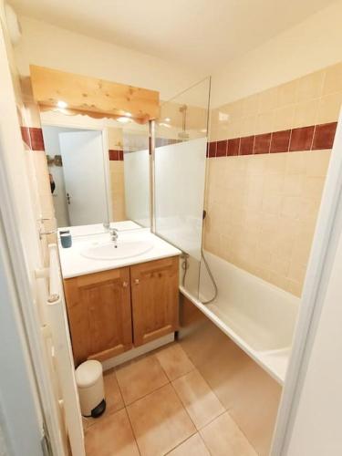 une salle de bain avec un lavabo et une baignoire dans l'établissement Les 3 Flocons, Meublé classé 3 étoiles , labellisé 4 grif, à Orcières