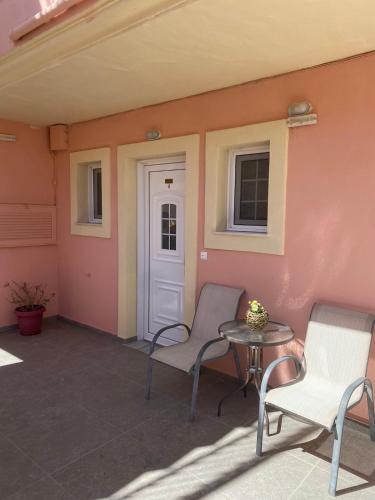 a patio with two chairs and a table and a door at Panorama View in Agios Stefanos