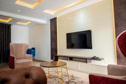 a living room with a flat screen tv on a wall at Lavani Apartment in Benin City