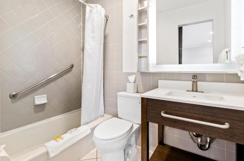a bathroom with a toilet and a sink and a tub at Signature Inn San Francisco Marina District in San Francisco