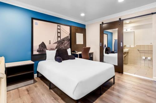 a bedroom with a large white bed and a bathroom at Signature Inn San Francisco Marina District in San Francisco