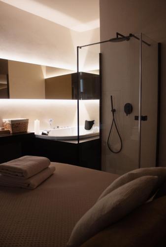 a bathroom with a shower and a bed and a tub at San Michele in Turi