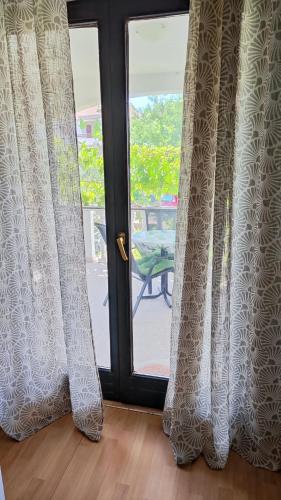 a door with curtains in front of a patio at Stela 2 in Povljana