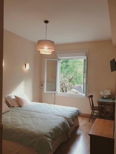 a bedroom with a large bed and a window at Aux gorges du Dourdou in Conques-en-Rouergue