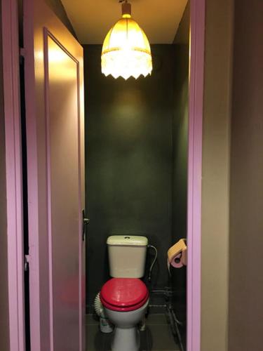 une salle de bain avec des toilettes rouges et une lumière dans l'établissement Room confortable next to the Olympic venues, à Villeneuve-la-Garenne