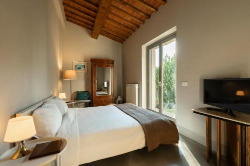 a bedroom with a bed and a tv and a window at Nonno Gino suite in Monte San Savino