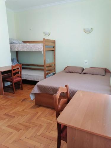 a bedroom with a bed and a desk and a table at Готель "Український Дворик" in Lviv