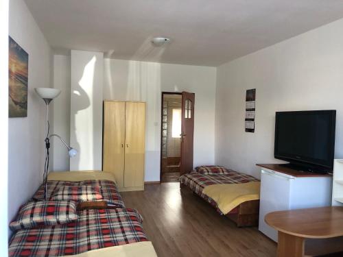 a room with two beds and a flat screen tv at "Kubania" POKOJE GOŚCINNE in Mielno
