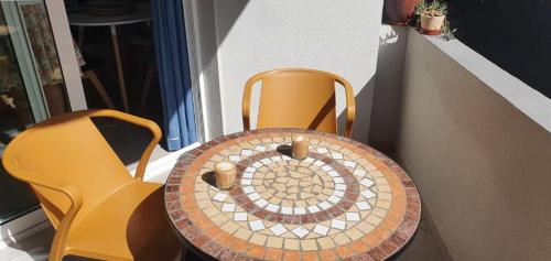 a table with two chairs and a table with a mosaic top at Corralejo Sun 119 Fuerteventura in Corralejo